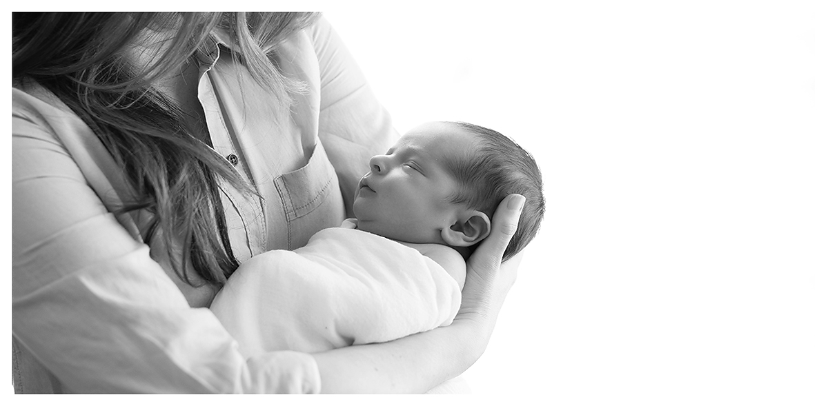 Mother holding newborn in black and white. Newborn photography by best cCT newborn photographer Kelli Dease.