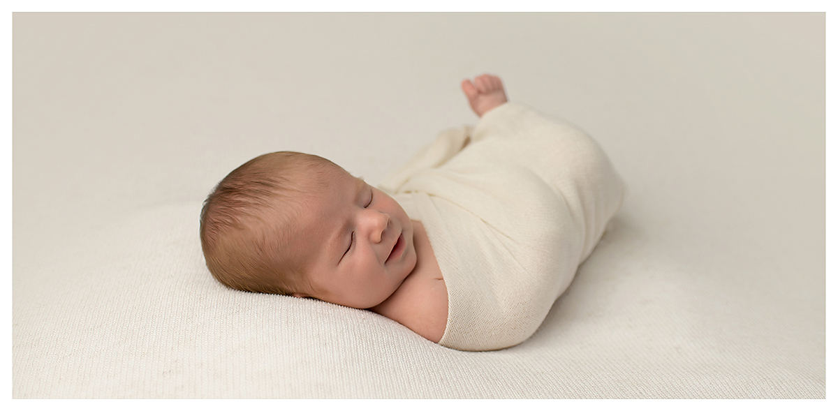 Newborn baby boy on soft cream blanket by top CT newborn photographer Kelli Dease