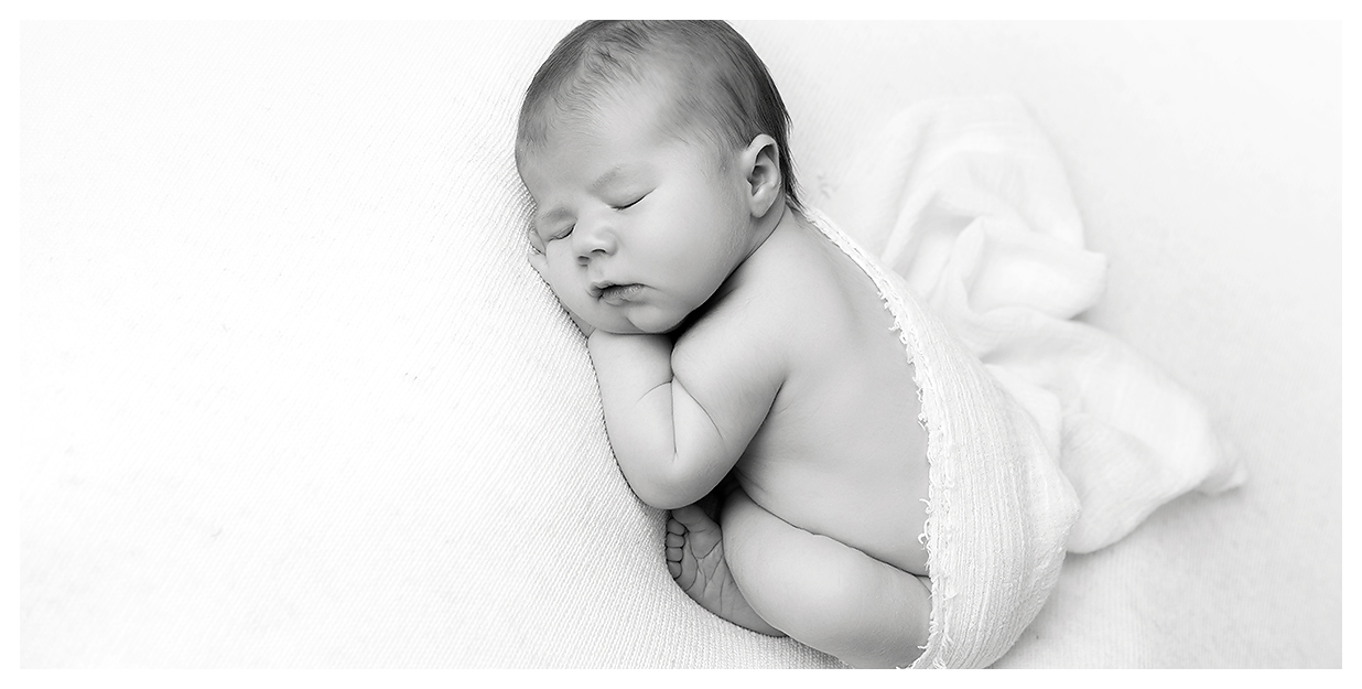 Black and white newborn on plain white backdrop by CT newborn photographer Kelli Dease
