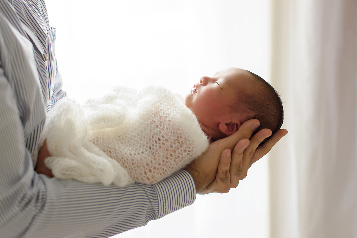 Newborn baby in dads arm. CT newborn photographer Kelli Dease.