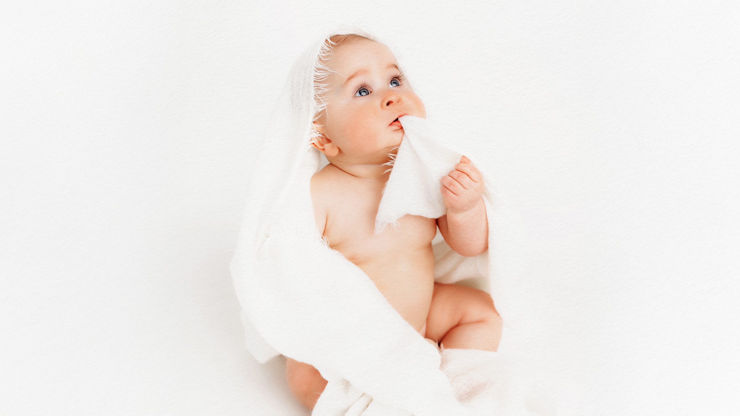 Sitting baby on white blanket