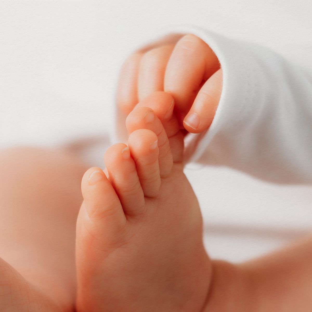 Close-up of a baby's chubby feet and toes against a soft white background