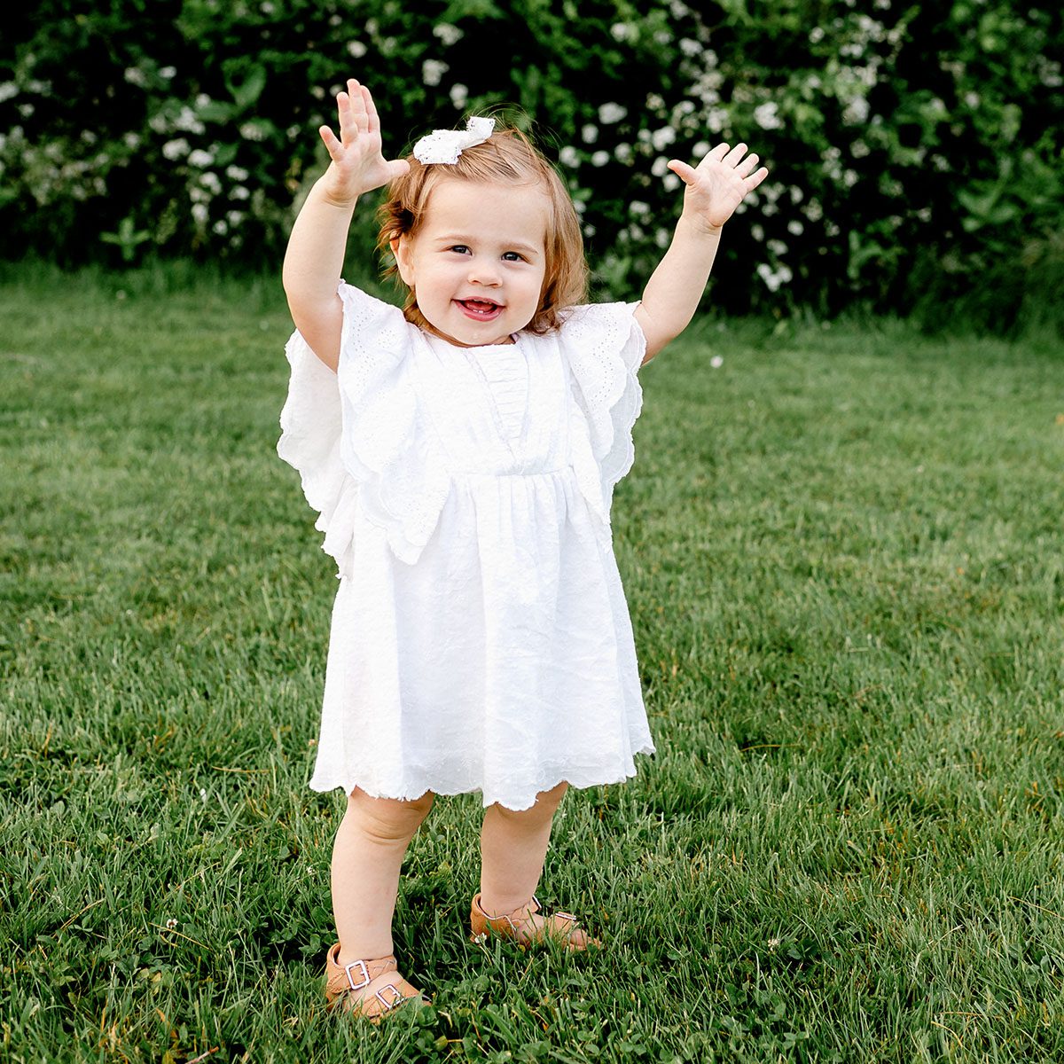 Outdoor childrens photo session in Simsbury, CT captured in a soft, minimalistic style, highlighting genuine smiles and natural poses in a scenic field.