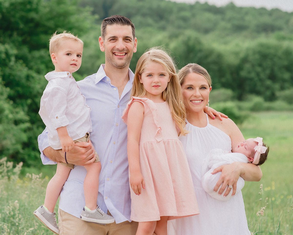 Outdoor Family Photoshoot with Newborn Baby and siblings 1 Sunset family photo session in a golden field featuring a blended family with a newborn and two siblings, showcasing natural connection and relaxed outdoor styling.