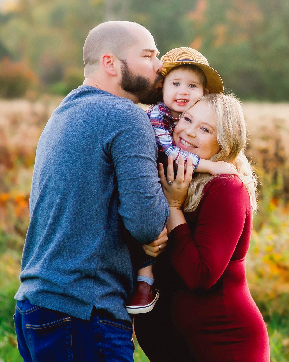 Fall family pictures with toddler in Connecticut – playful outfit ideas and natural, candid moments. Candid fall family photography in Connecticut field with warm, earthy wardrobe for parents and child.