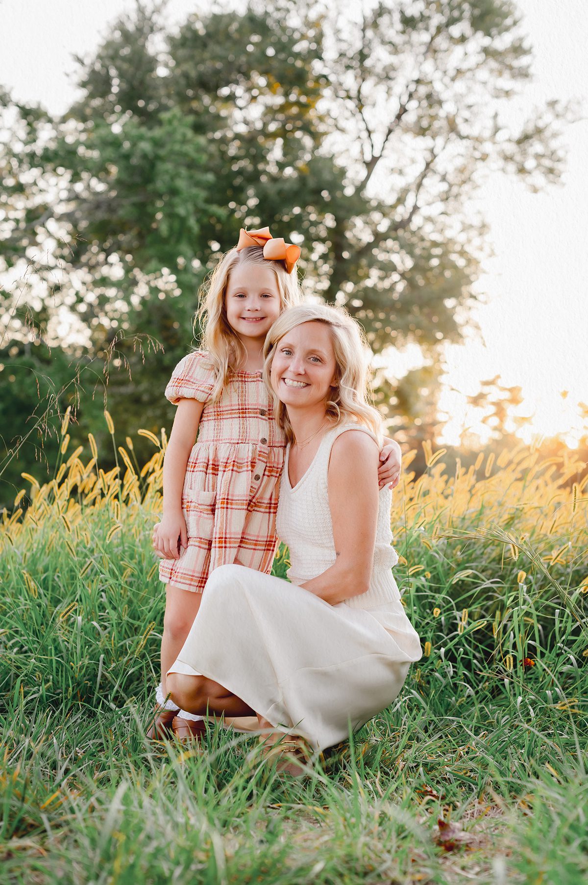 Mother and daughter in a field of golden tall grasses in early fall in Connecticut.