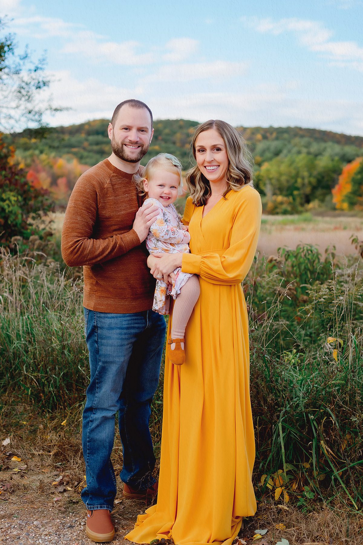 What to wear for fall family pictures in Connecticut – mustard yellow dress and earthy tones during an outdoor family session.