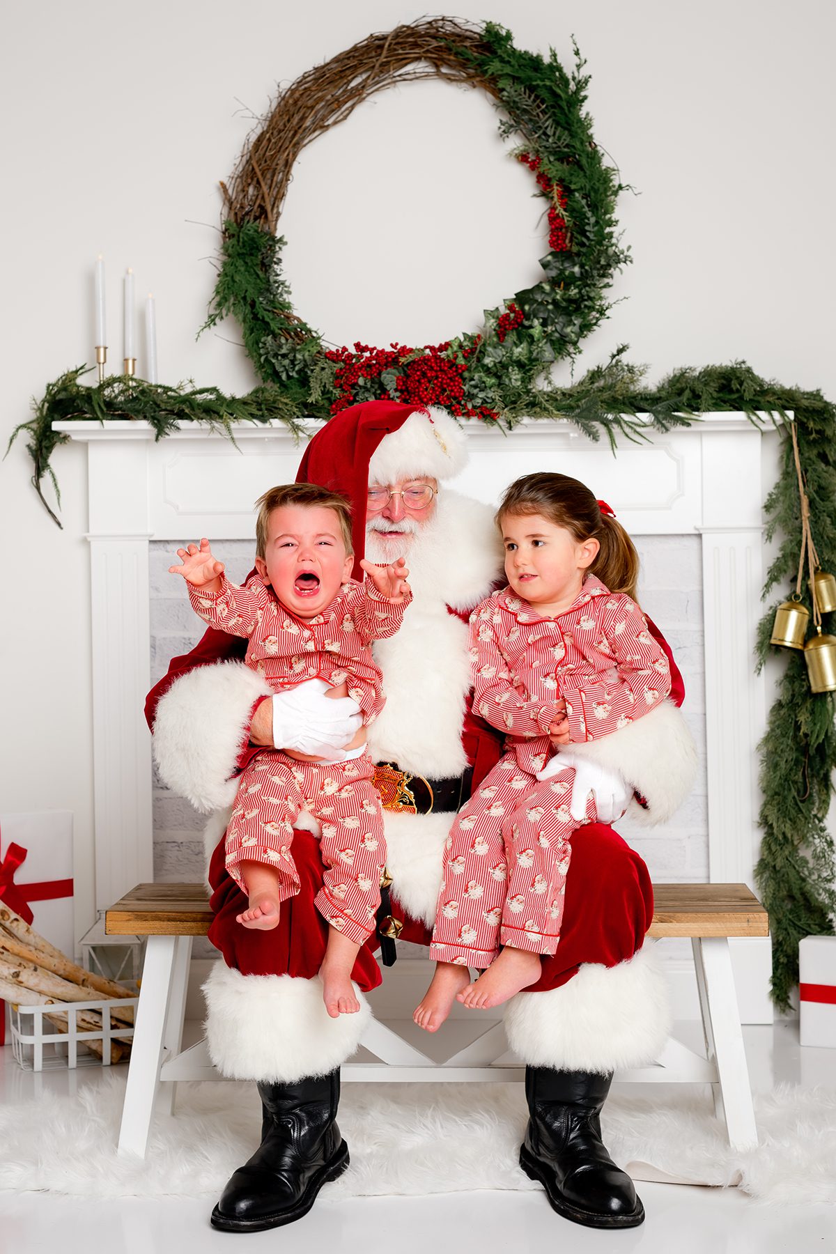 Fun studio santa photo session with little boy crying.