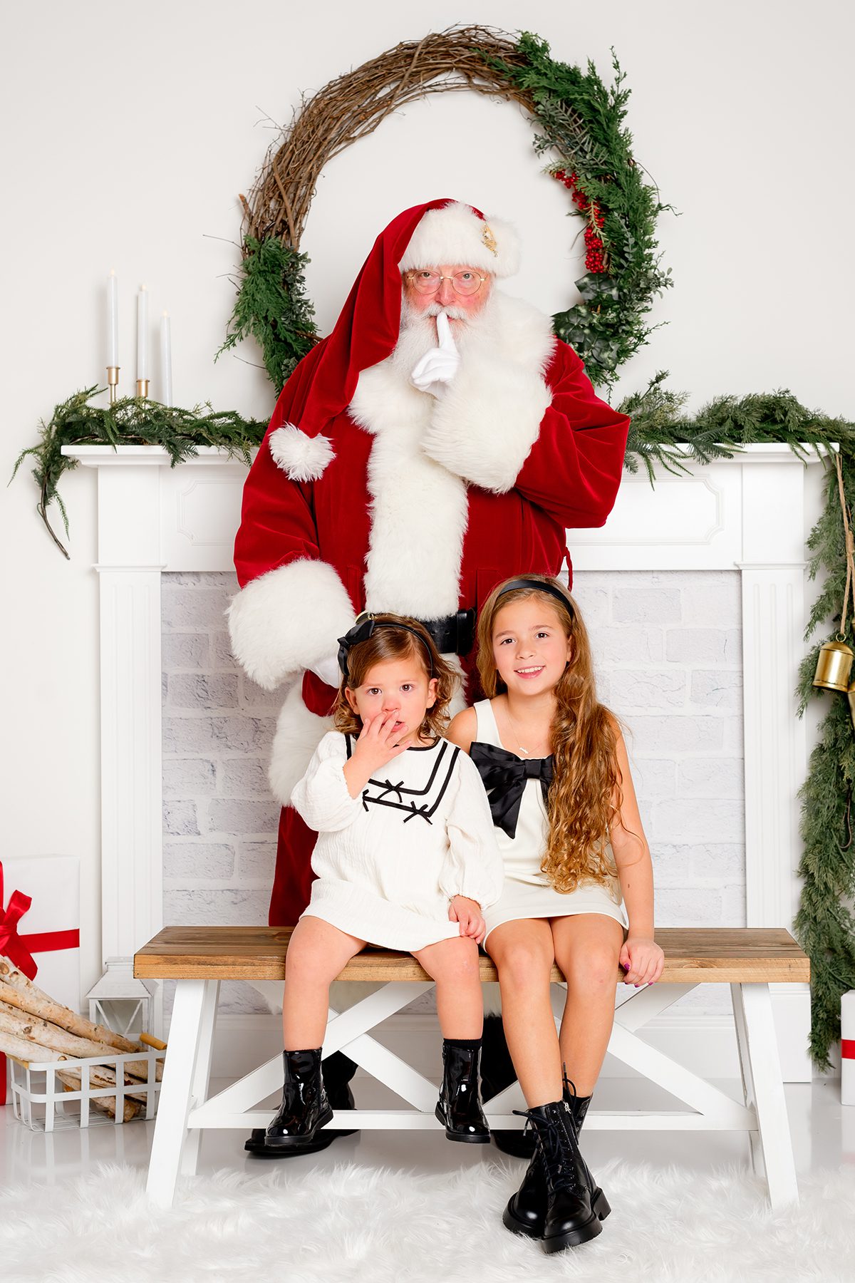 07_SANTA_CHRISTMAS_PHOTOS Santa posing with siblings for a traditional holiday portrait.