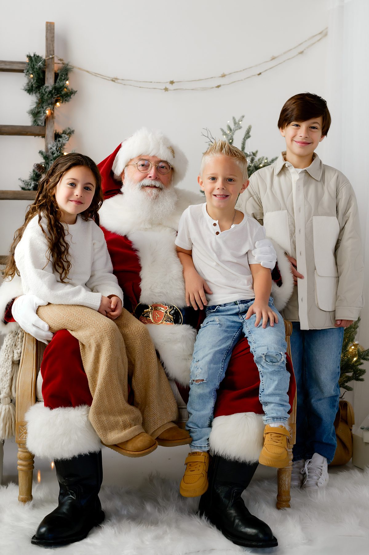 Santa posing with siblings for a traditional holiday portrait.