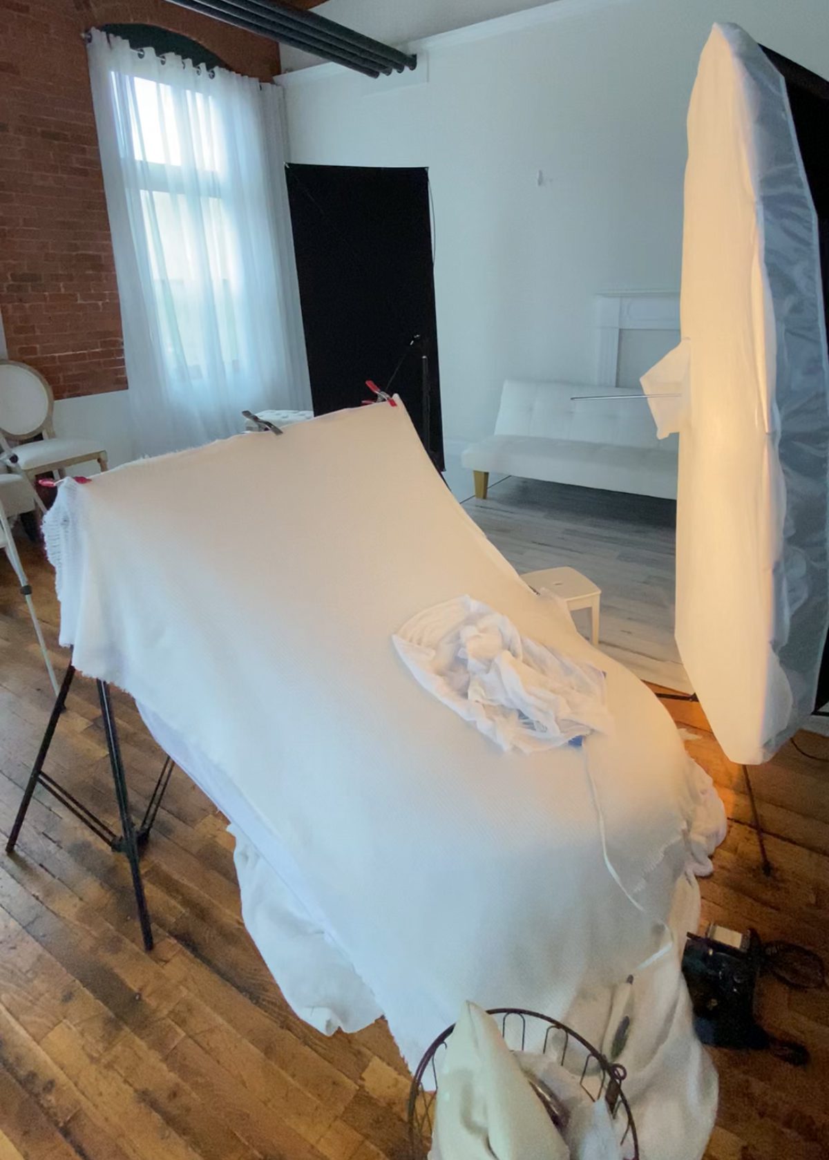 a behind the scenes look at a newborn photoshoot setup featuring a beanbag and a studio light