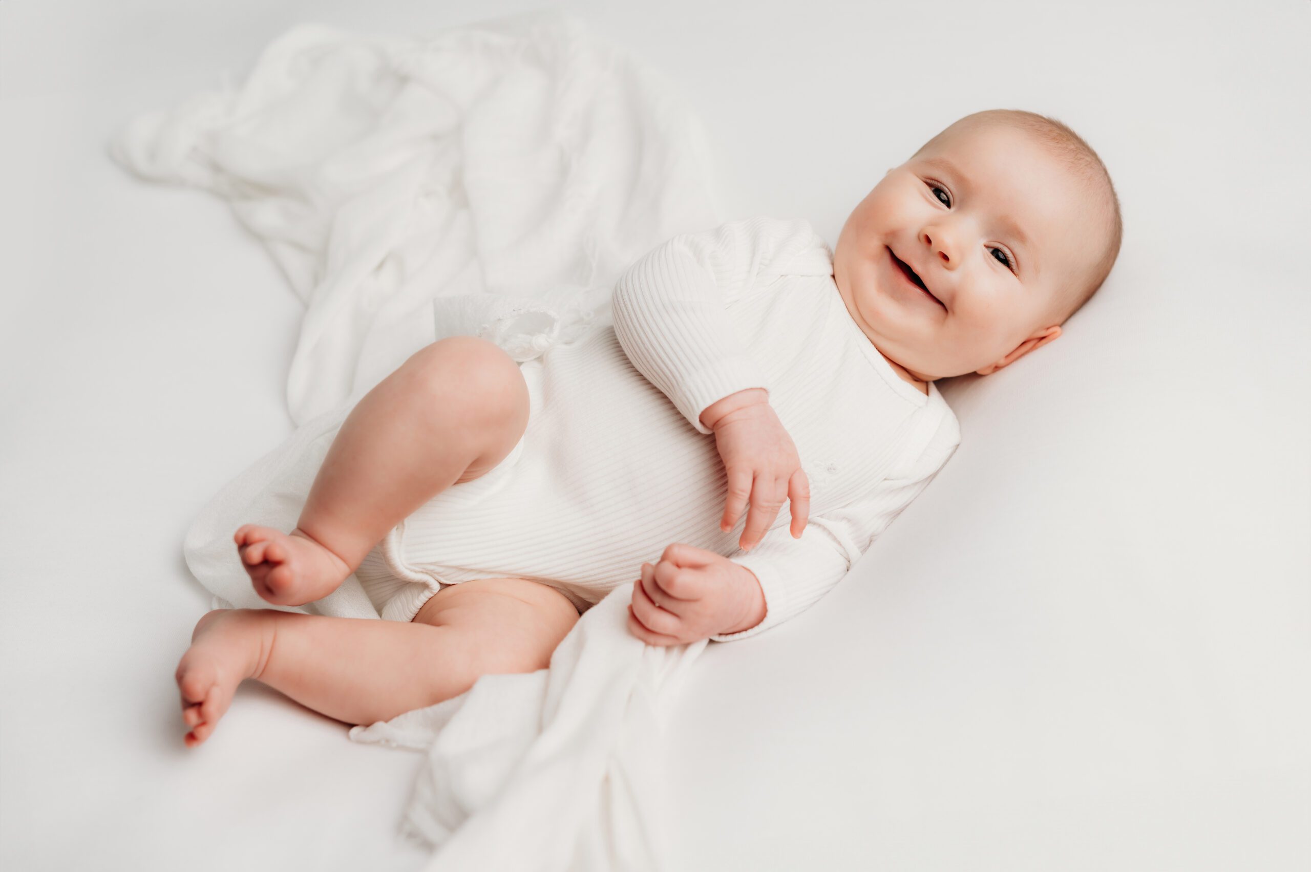 a simple and minimalistic newborn photo session with a six week old baby on a plain white backdrop
