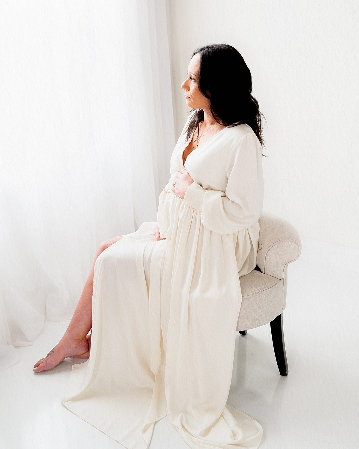 Pregnant woman in cream wrap dress, solo studio portrait, soft natural light, Kelli Dease Photography Farmington CT