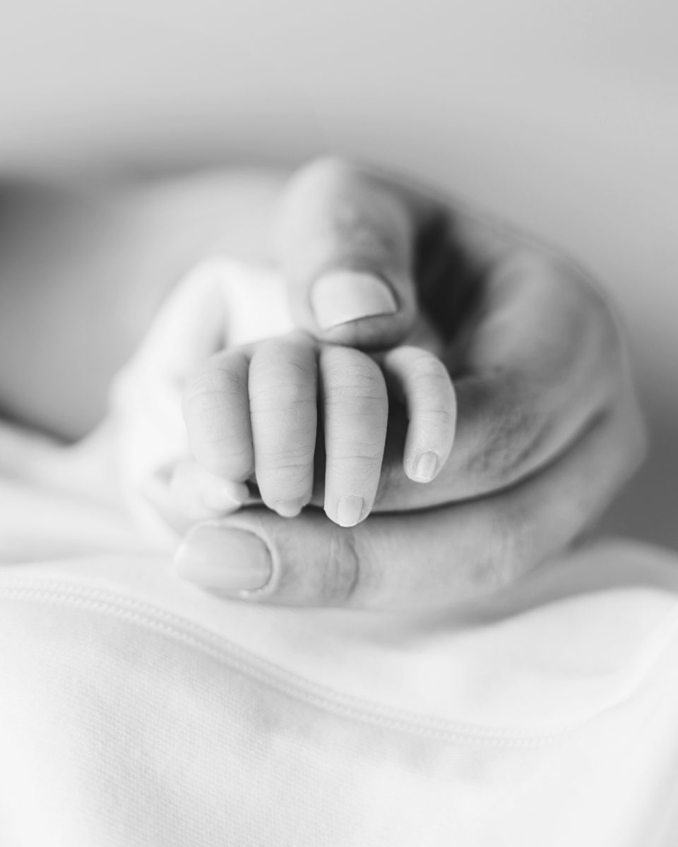 Newborn baby gripping a parent's finger, a close-up detail from a studio newborn session in Farmington CT