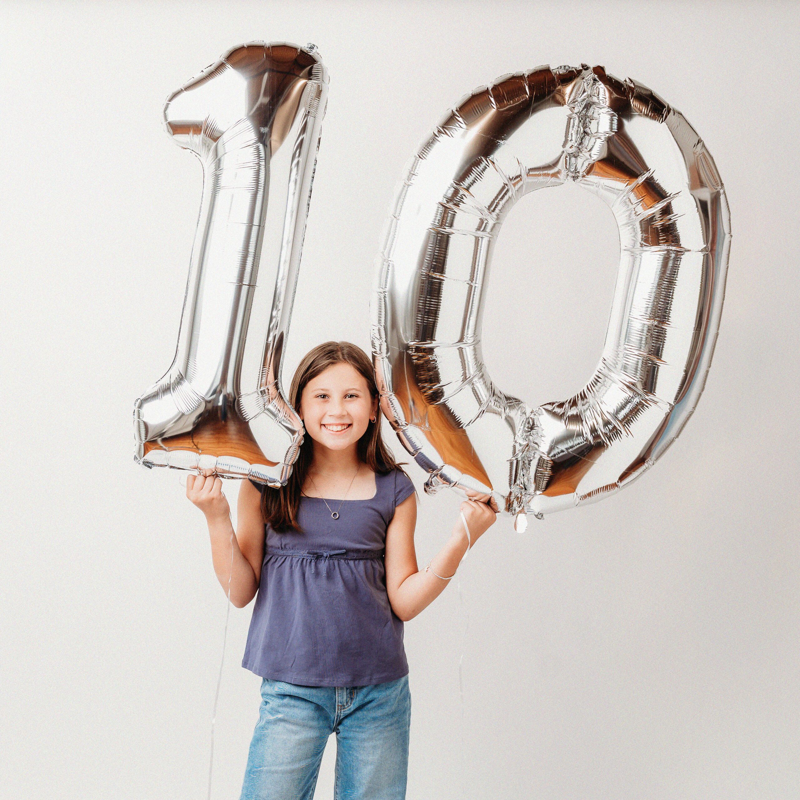 DAMN_34 WEB Girl holding silver number 10 balloons during 10th birthday portrait session at Kelli Dease Photography, Connecticut