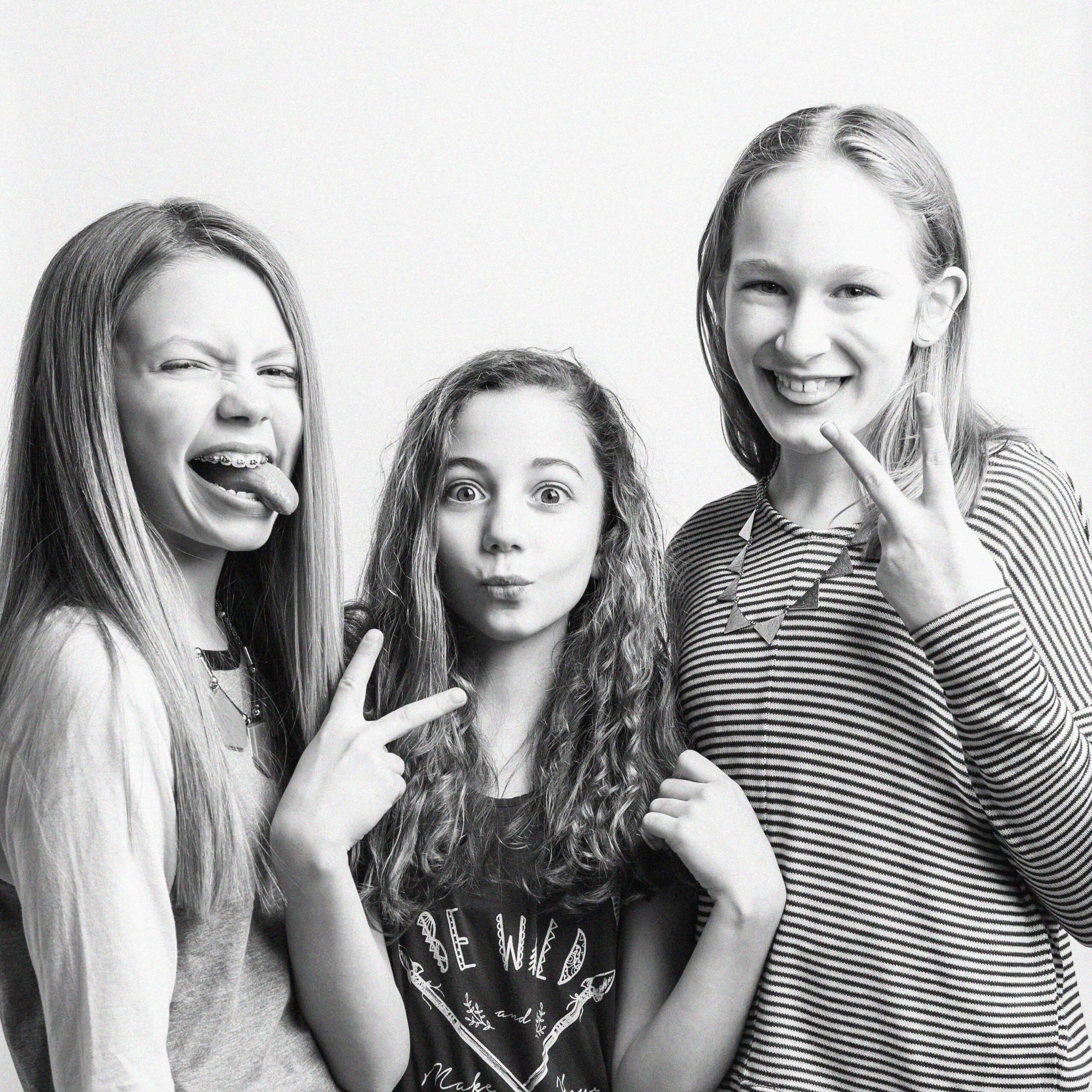 KDP_7089 BW SQ_WEB Three preteen girls sticking out their tongues and making hand gestures in black and white birthday portrait, Kelli Dease Photography, Farmington CT