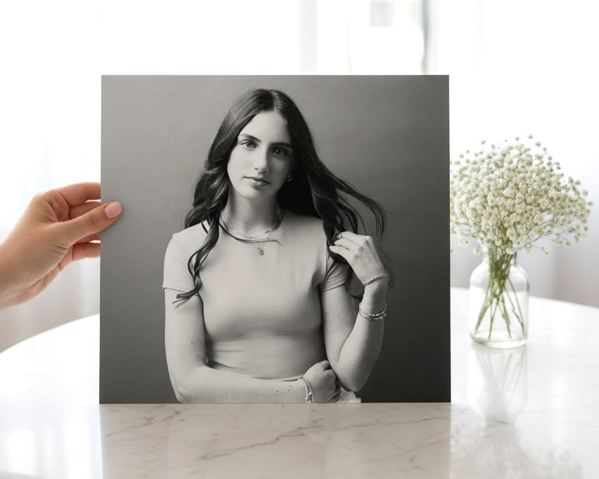 A hand holding a black and white print of a teenage girl by Kelli Dease Photography in Farmington, Connecticut